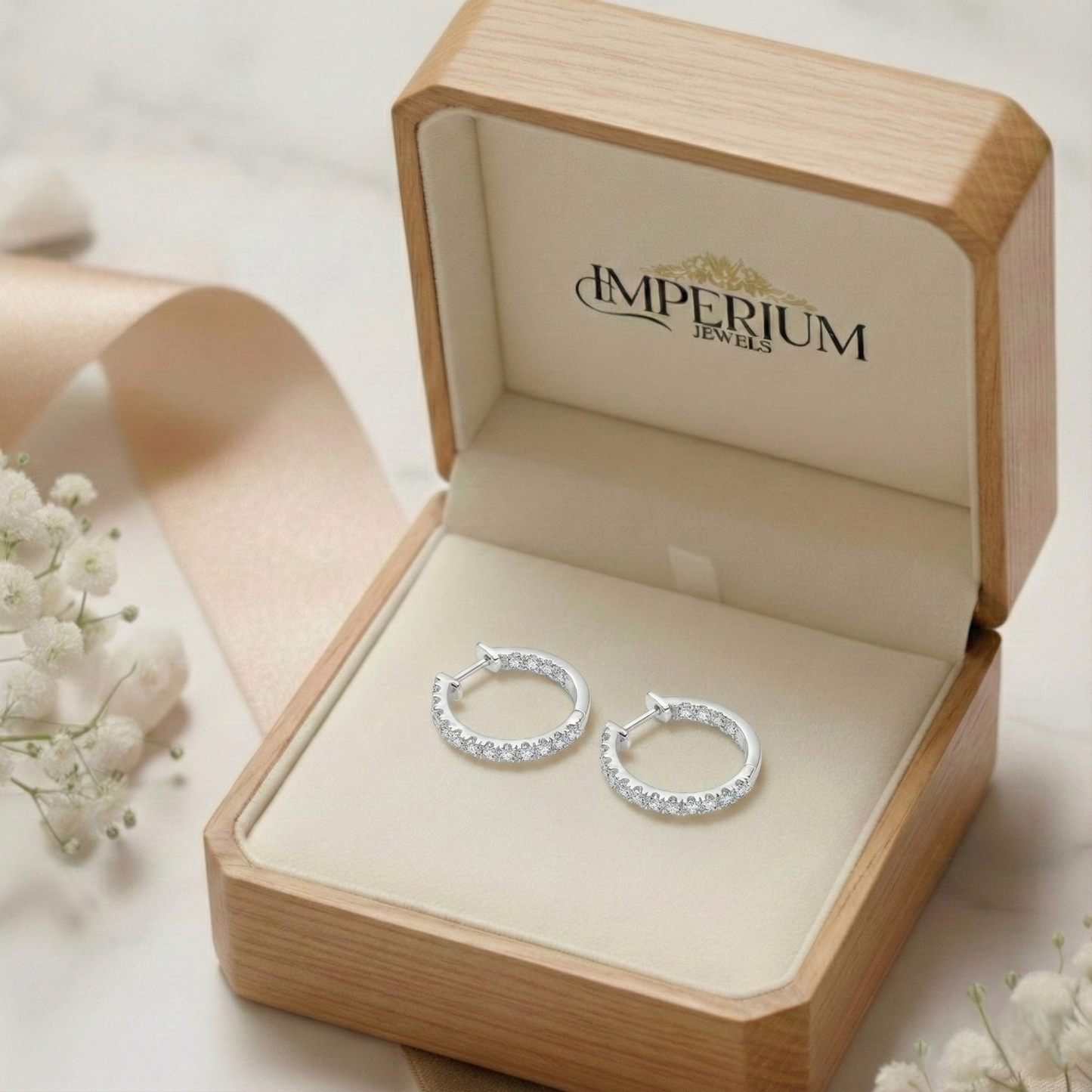 Silver hoop earrings in an open jewelry box with 'Imperium Jewels' branding.