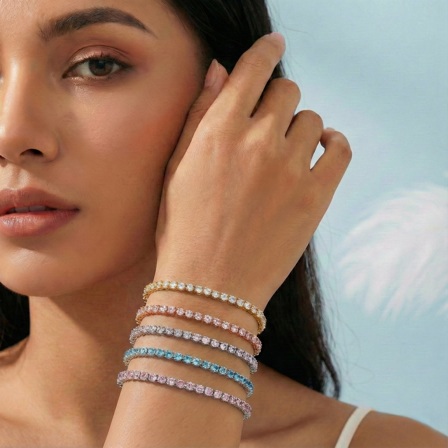 Woman wearing multiple bracelets on her wrist with a clear blue sky background