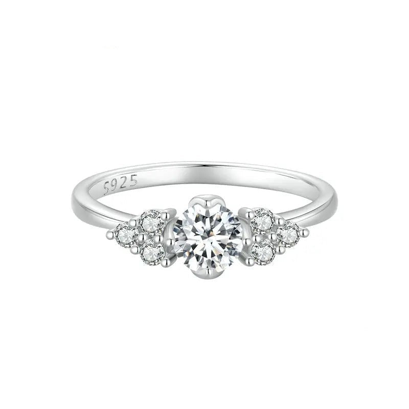 Silver ring with a central diamond and smaller diamonds on a white background