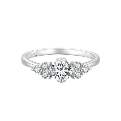 Silver ring with a central diamond and smaller diamonds on a white background