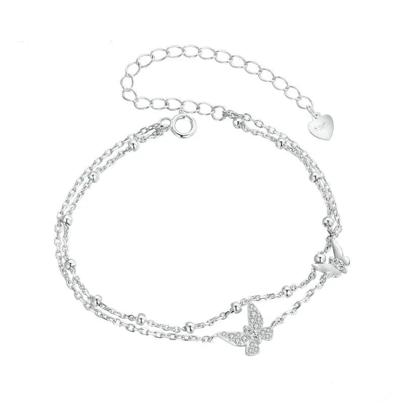 Silver bracelet with butterfly charms on a white background
