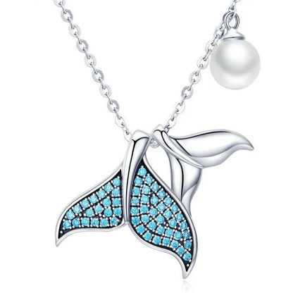Mermaid tail necklace with blue gemstones and a pearl on a white background