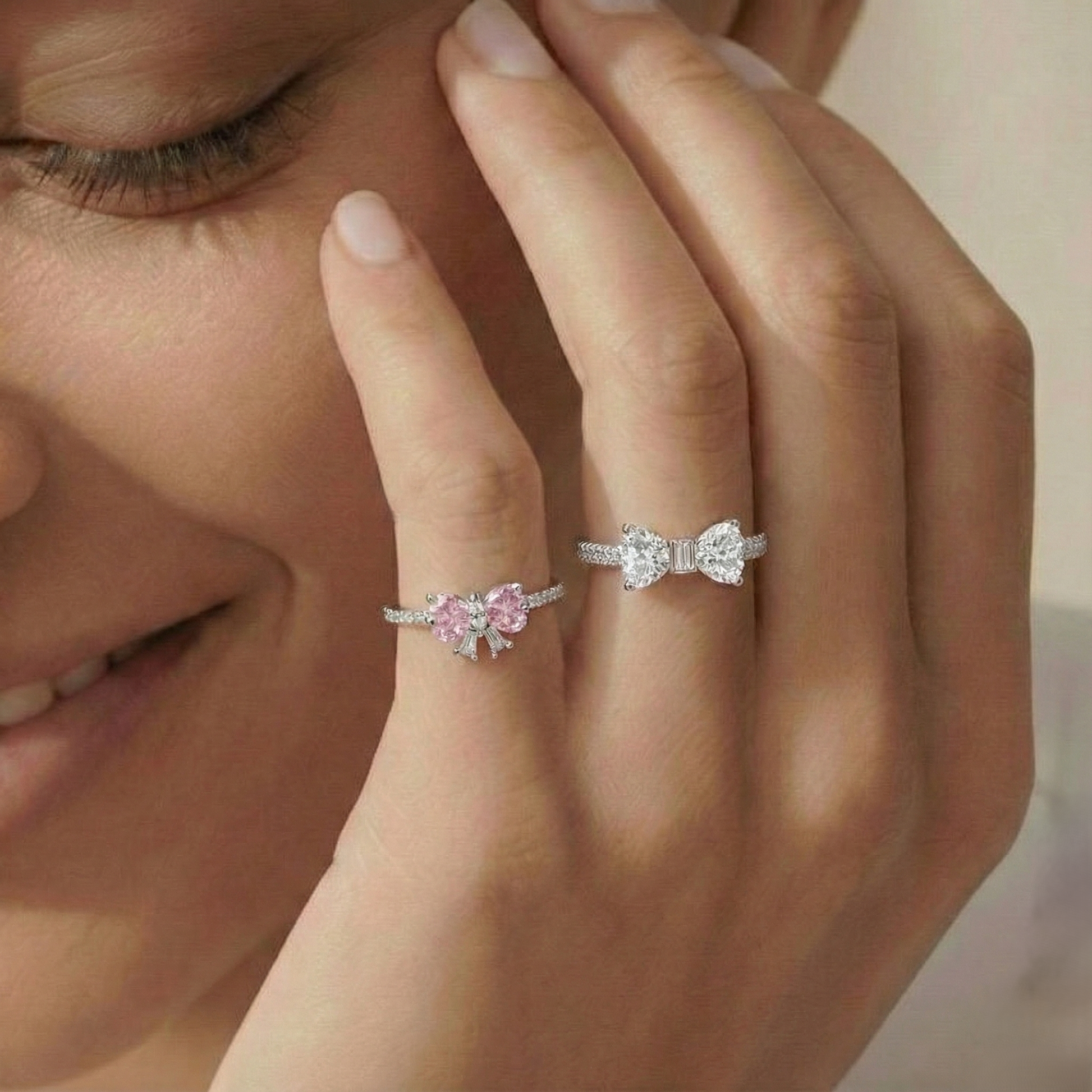 Close-up of a woman's hand wearing two diamond rings with a blurred background