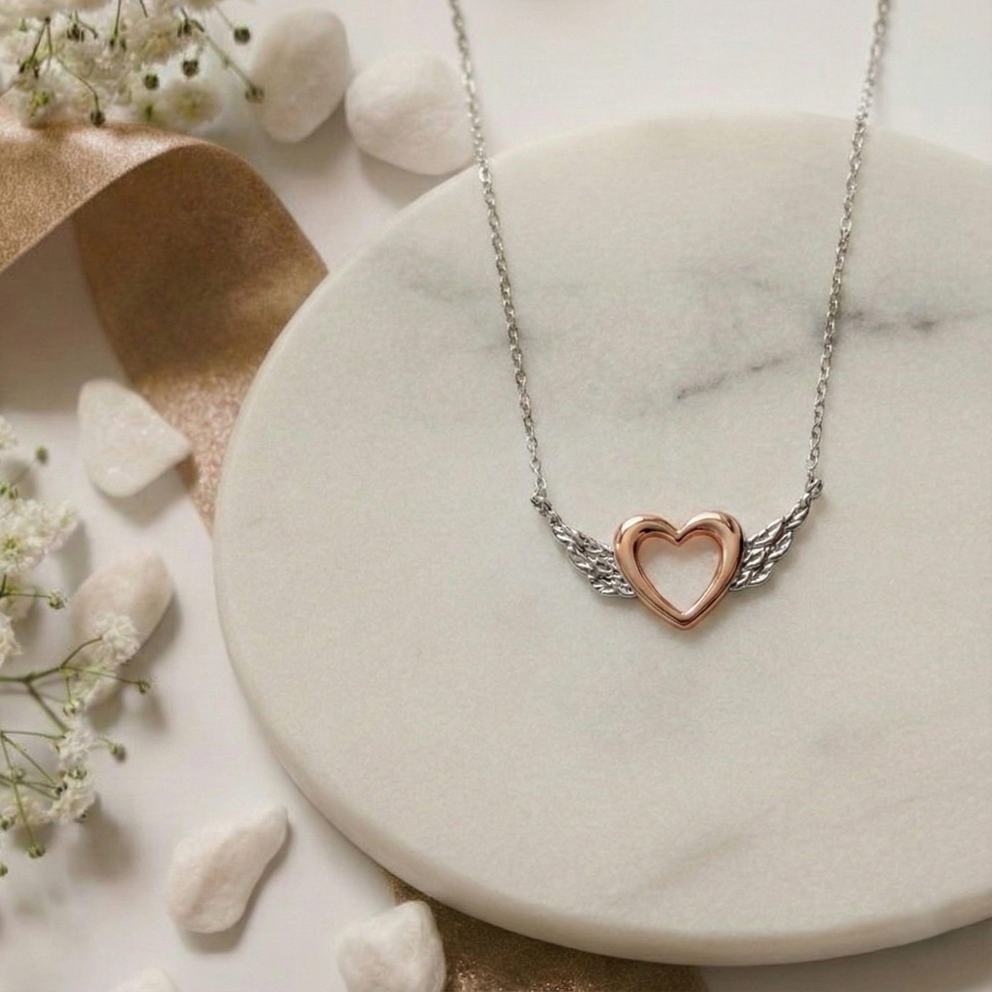 Heart-shaped necklace on a marble surface with flowers