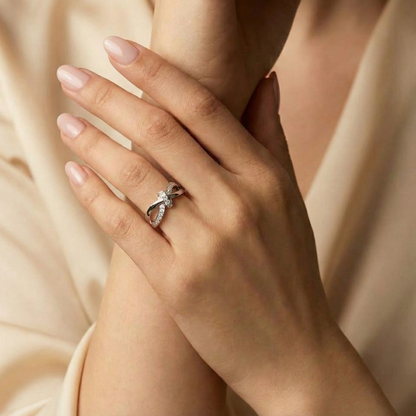 Close-up of a hand wearing a diamond ring with a soft beige background