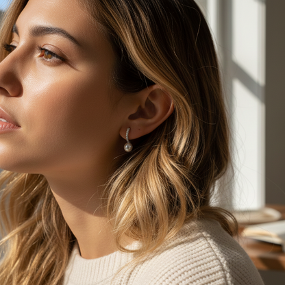 Close-up of a woman wearing pearl earrings with a blurred background