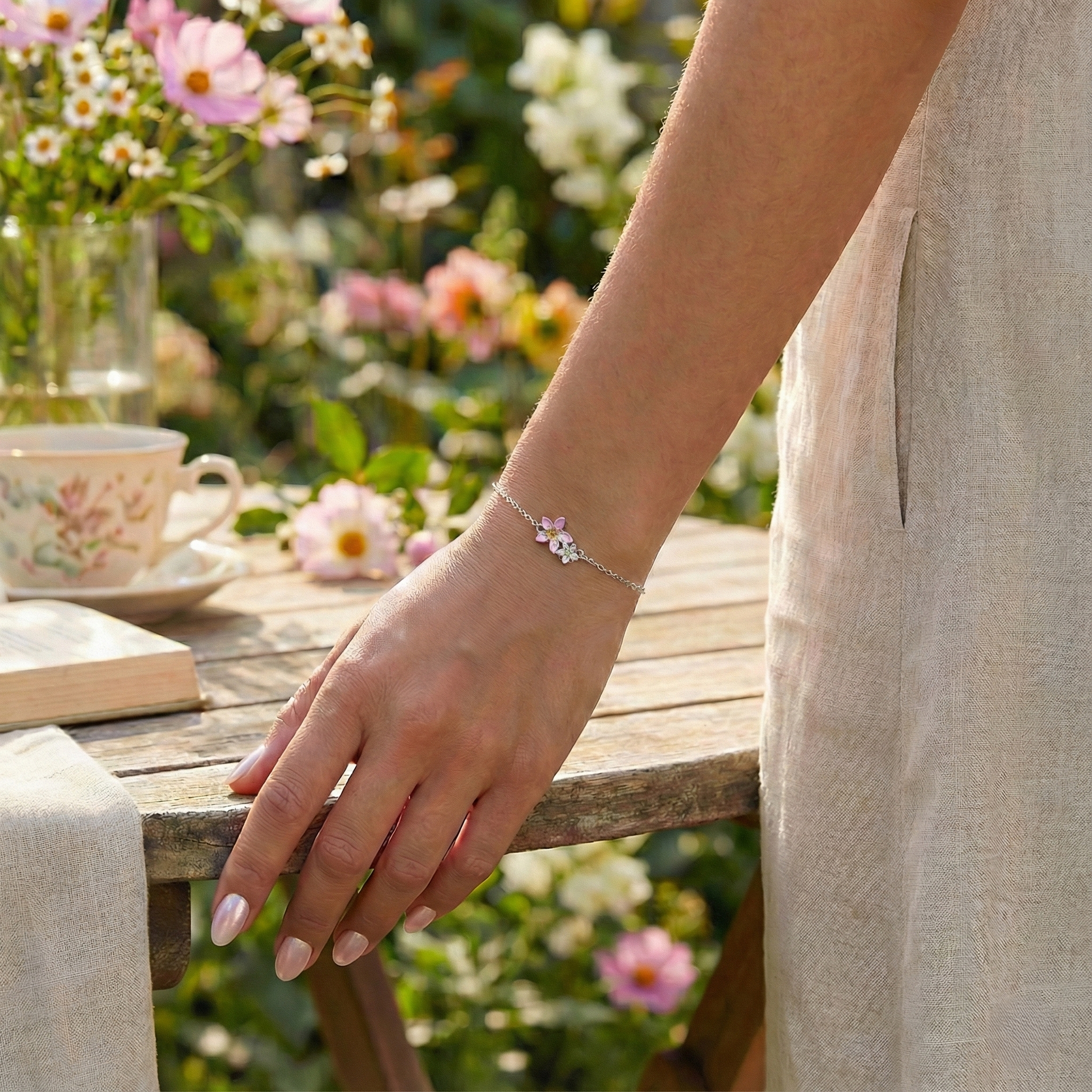 Person wearing a bracelet with a floral design in a garden setting