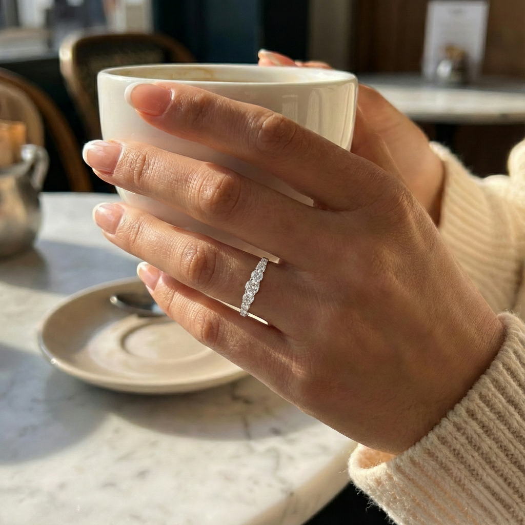 Hand holding a white mug with a blurred background of a kitchen setting