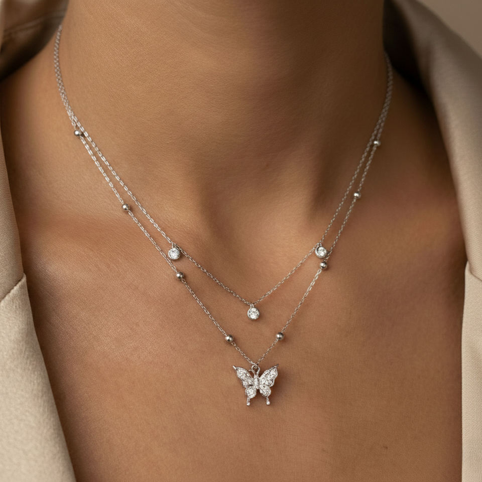 Butterfly necklace on a person wearing a beige garment