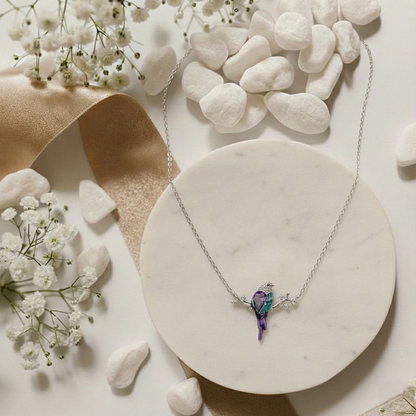 Necklace with a butterfly pendant on a marble surface with flowers and stones