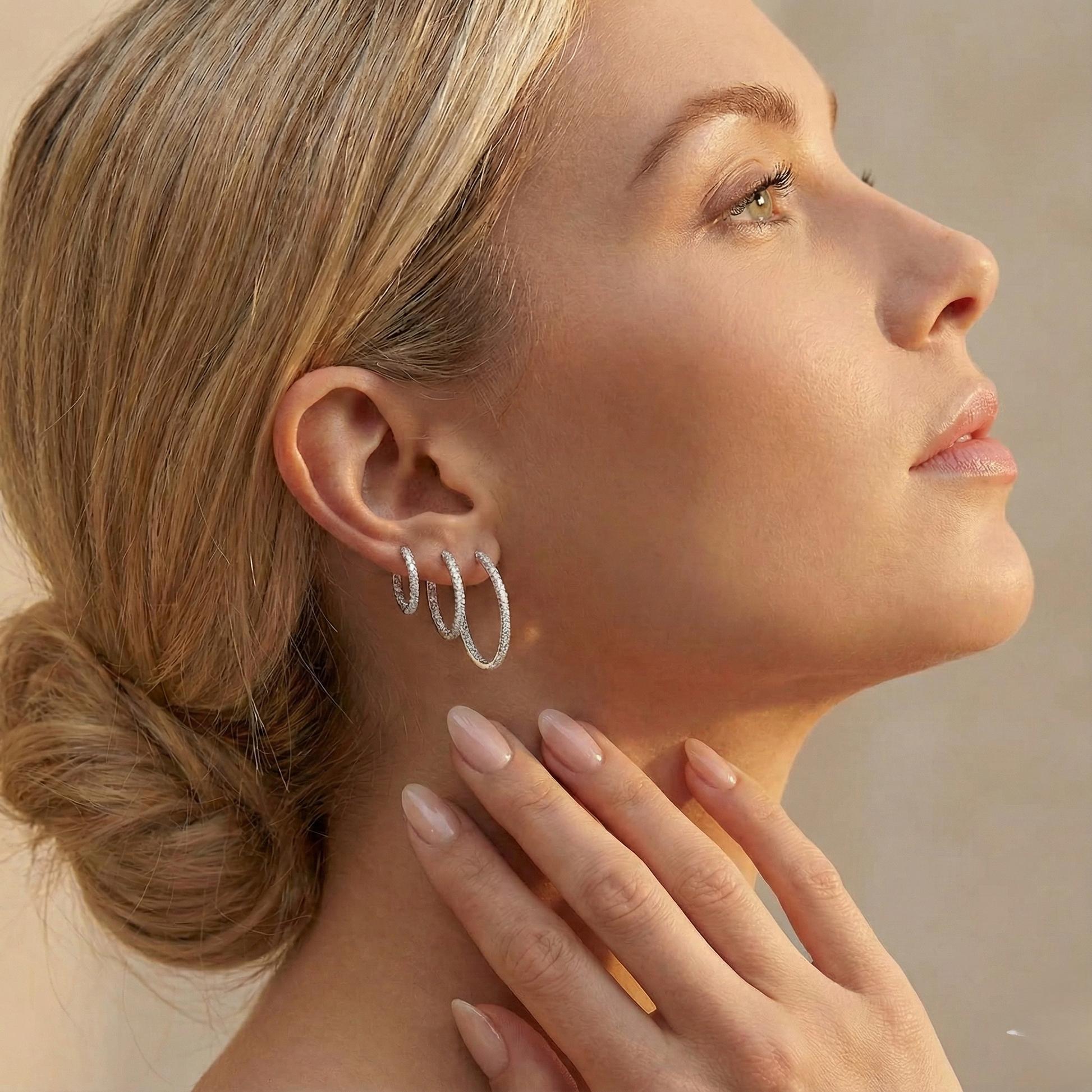 Close-up of a woman wearing silver hoop earrings with a blurred background