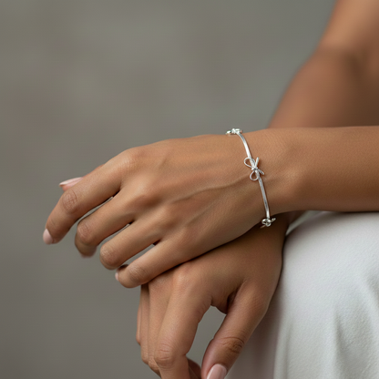 Silver bracelet on a wrist with a neutral background