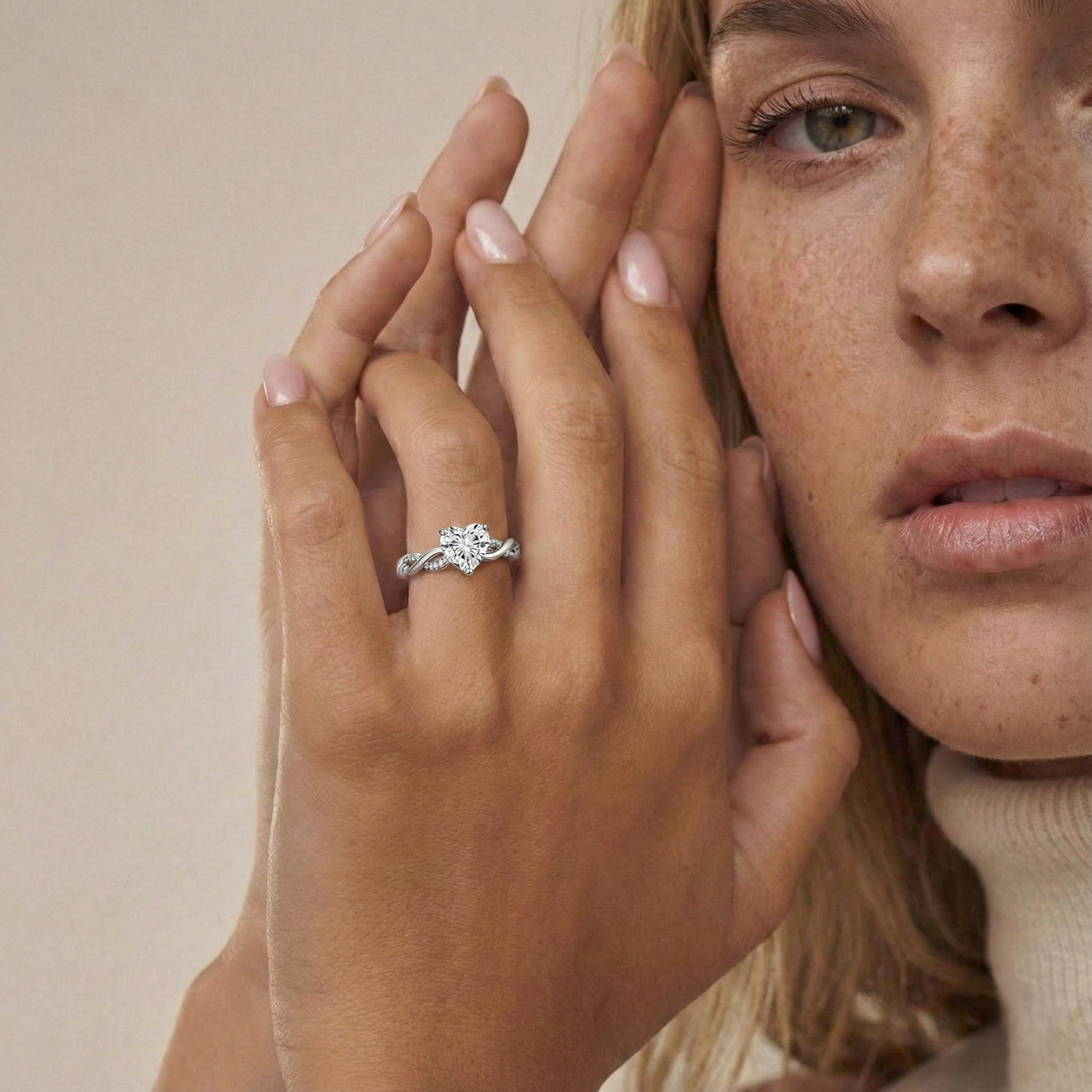 Close-up of a woman's hand wearing a silver ring with a beige background