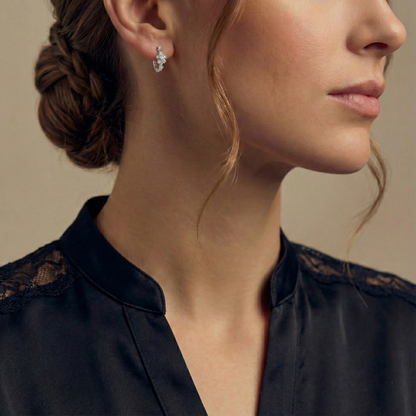 Close-up of a woman wearing a diamond earring with a neutral background