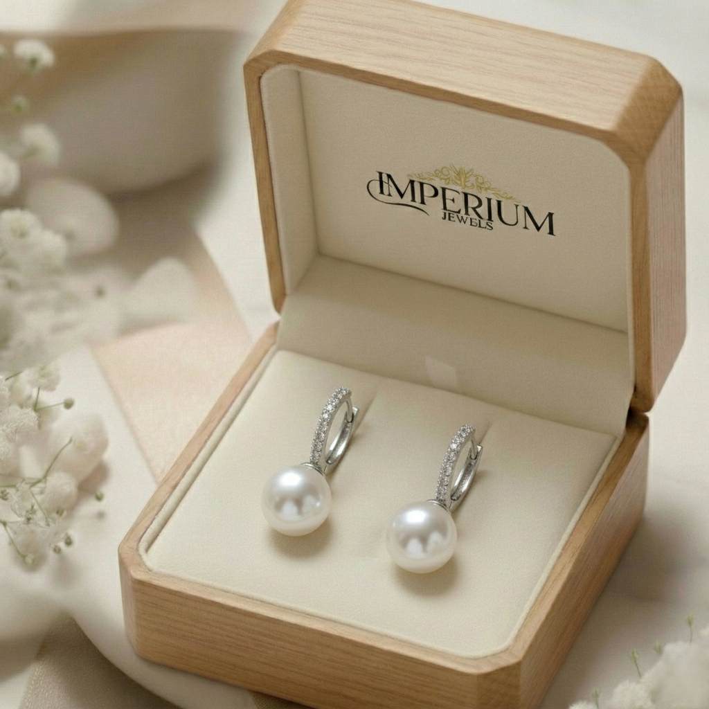 Pearl earrings in a 'Imperium Jewels' box with delicate flowers around.