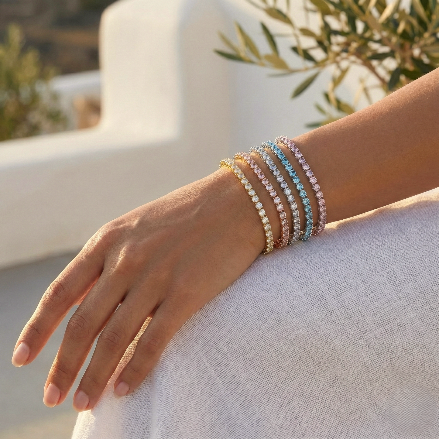 Hand wearing multiple colorful bracelets with a blurred natural background