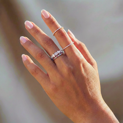 Hand wearing multiple rings with a blurred background