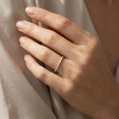 Close-up of a hand wearing a silver ring on a neutral background