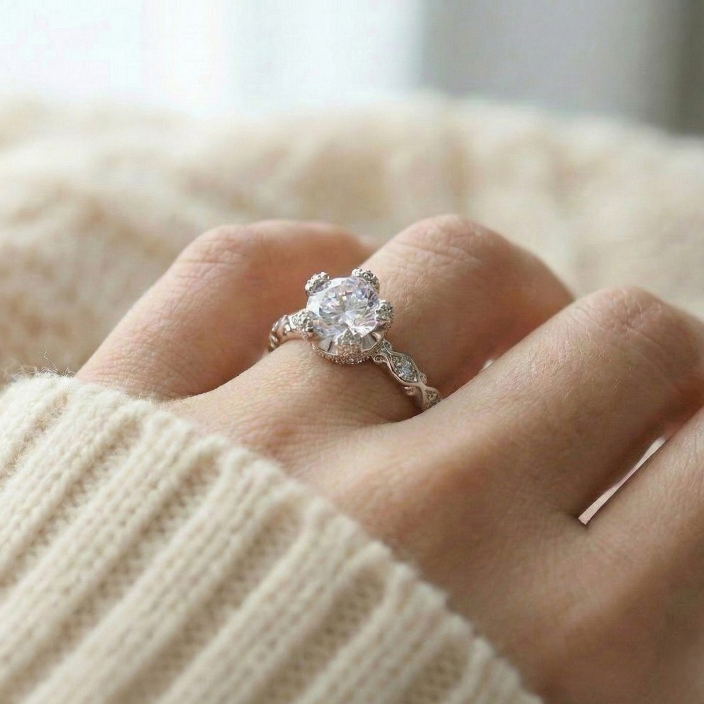 Close-up of a hand wearing a diamond ring with a blurred background