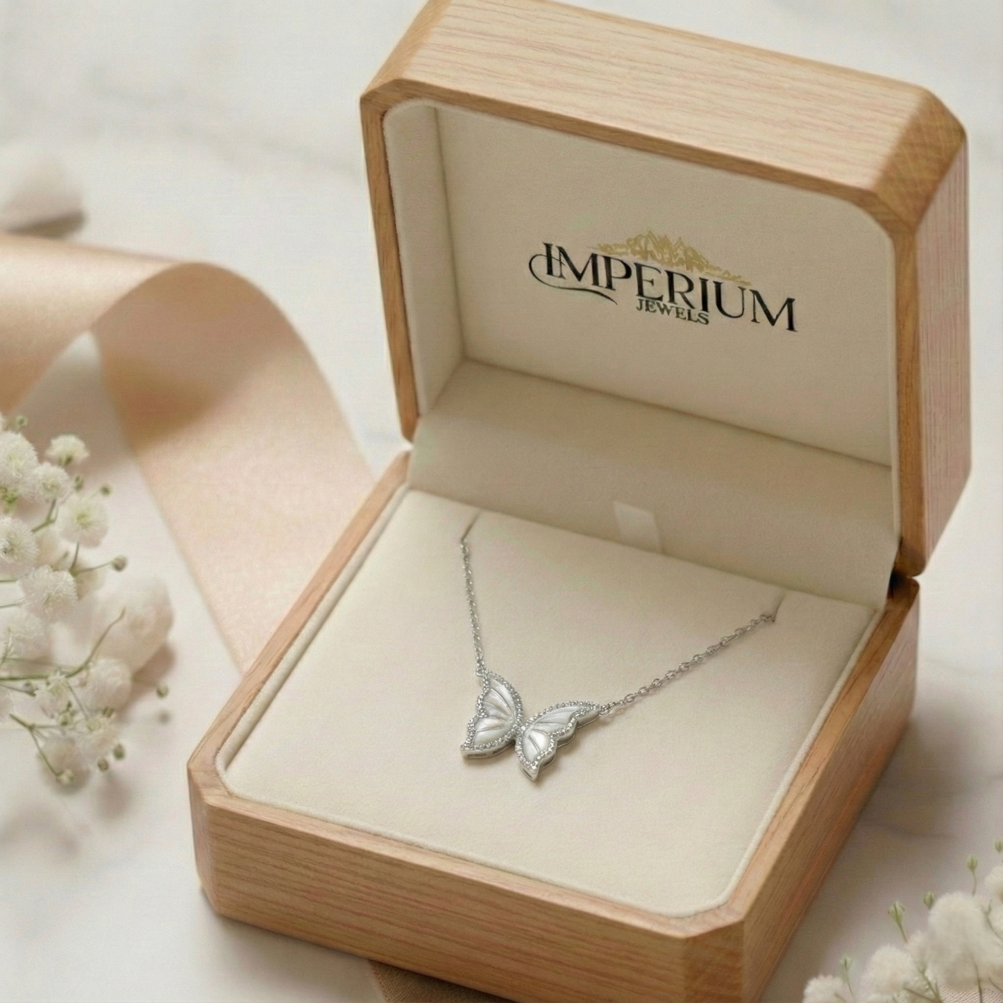 Butterfly necklace in an open wooden jewelry box with 'Imperium Jewels' branding.