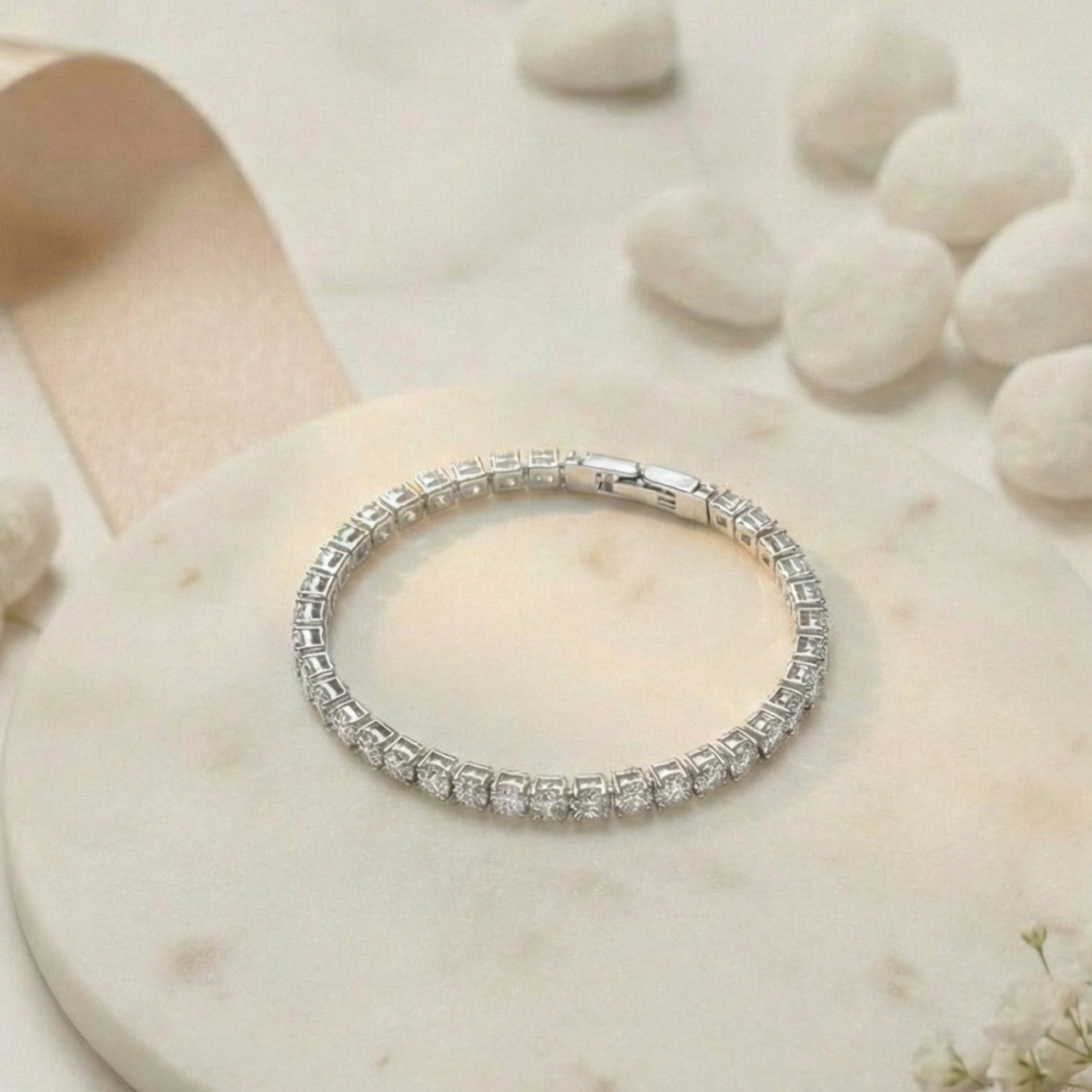 Silver bracelet with clear stones on a beige stone surface
