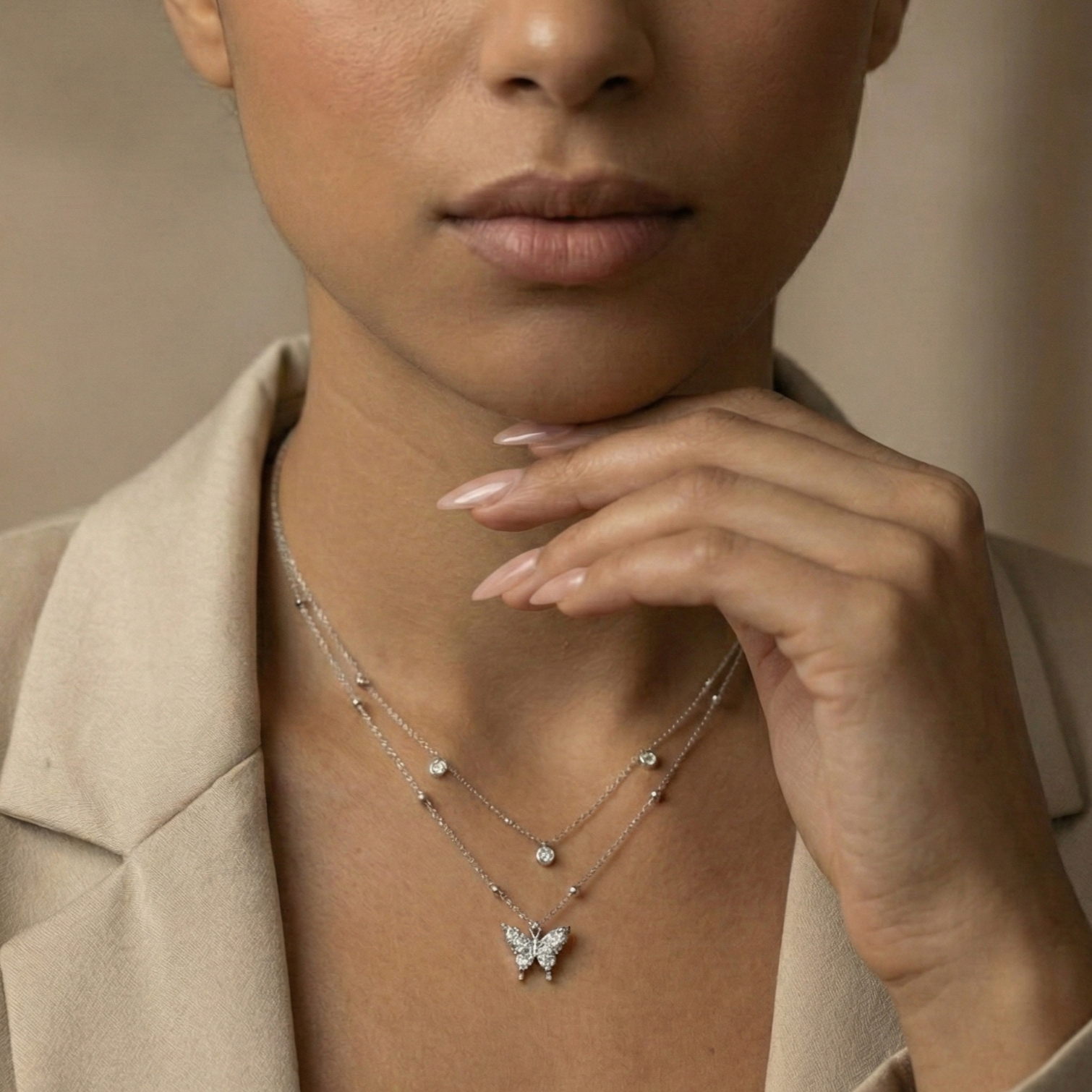 Woman wearing a butterfly necklace with a neutral background