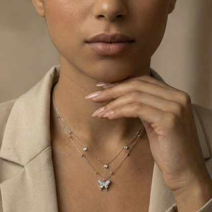 Woman wearing a butterfly necklace with a neutral background