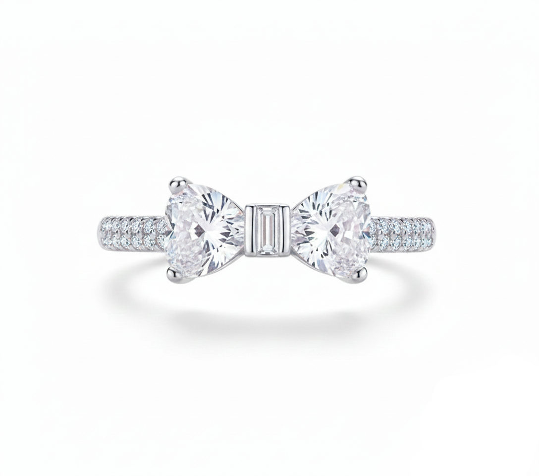 Silver bow-shaped ring with clear gemstones on a white background, featuring 'Real Sterling Silver 925' stamp.