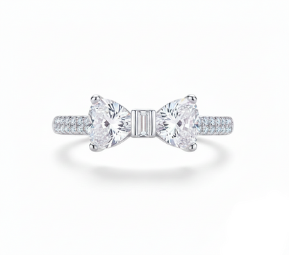 Silver bow-shaped ring with clear gemstones on a white background, featuring 'Real Sterling Silver 925' stamp.