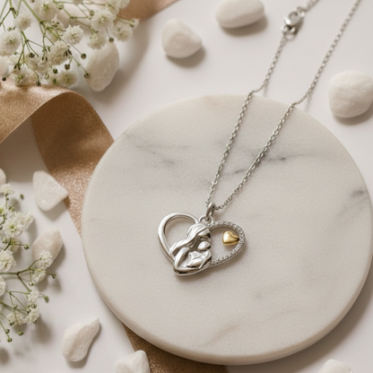 Close-up of silver heart pendant highlighting mother-and-child silhouette detail
